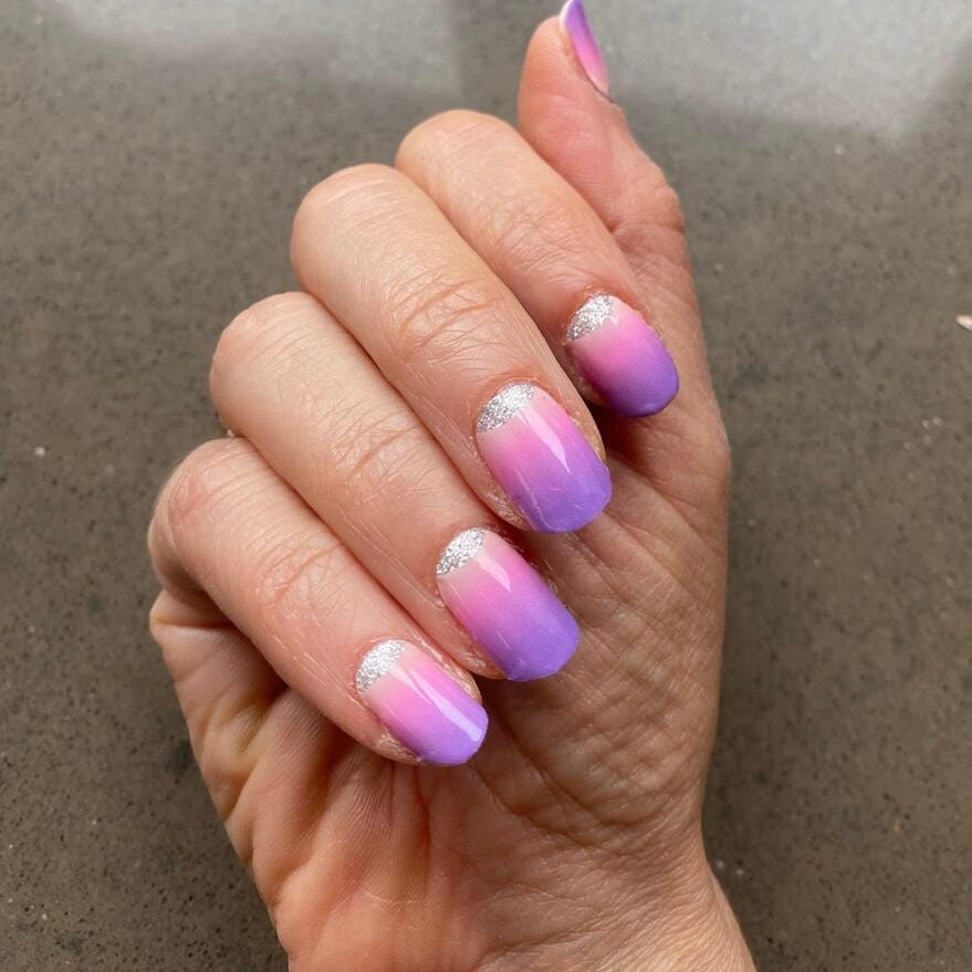Pink to purple ombre nail wraps with holographic shimmer on hand