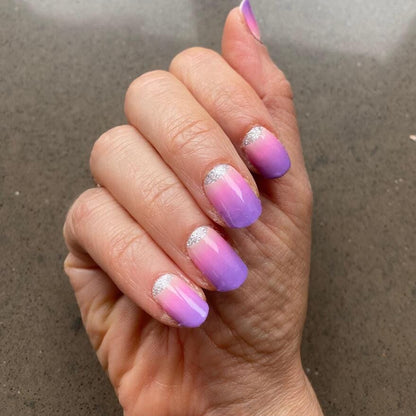Pink to purple ombre nail wraps with holographic shimmer on hand