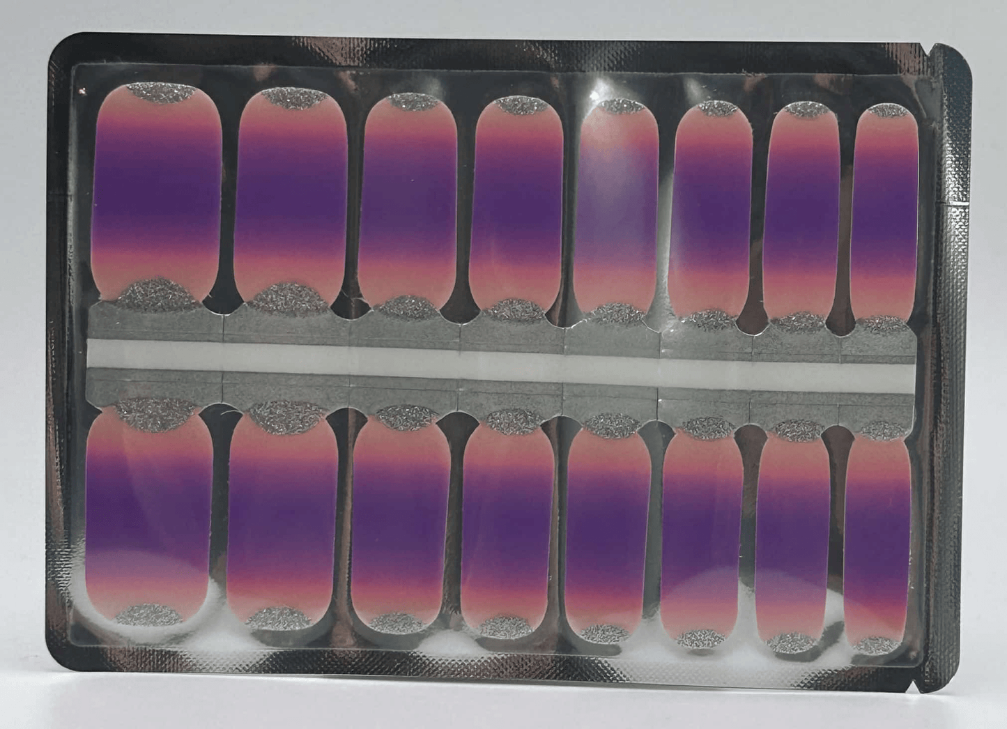 Purple to pink gradient nail wraps with silver glitter tips in packaging display