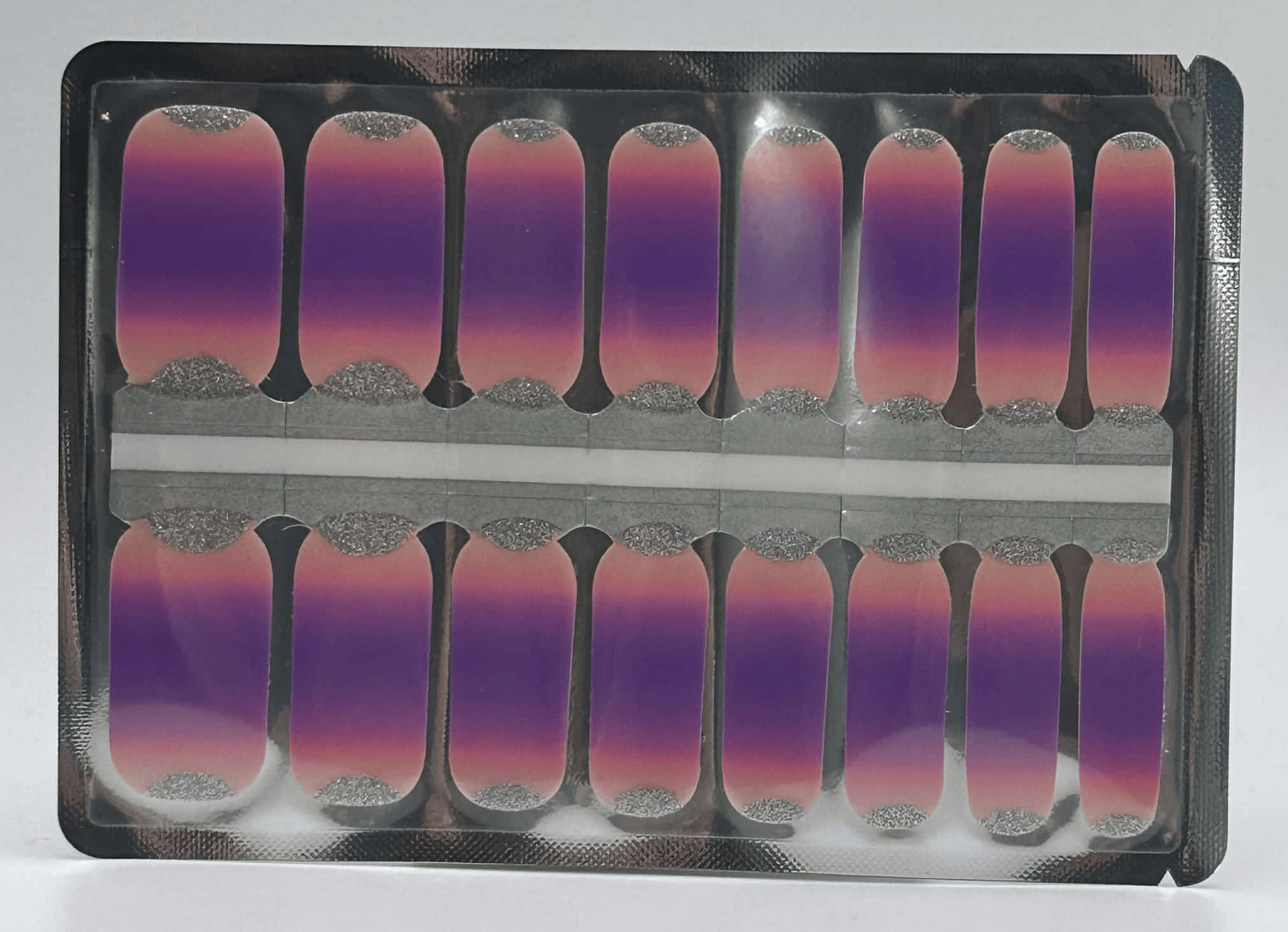 Purple to pink gradient nail wraps with silver glitter tips in packaging display