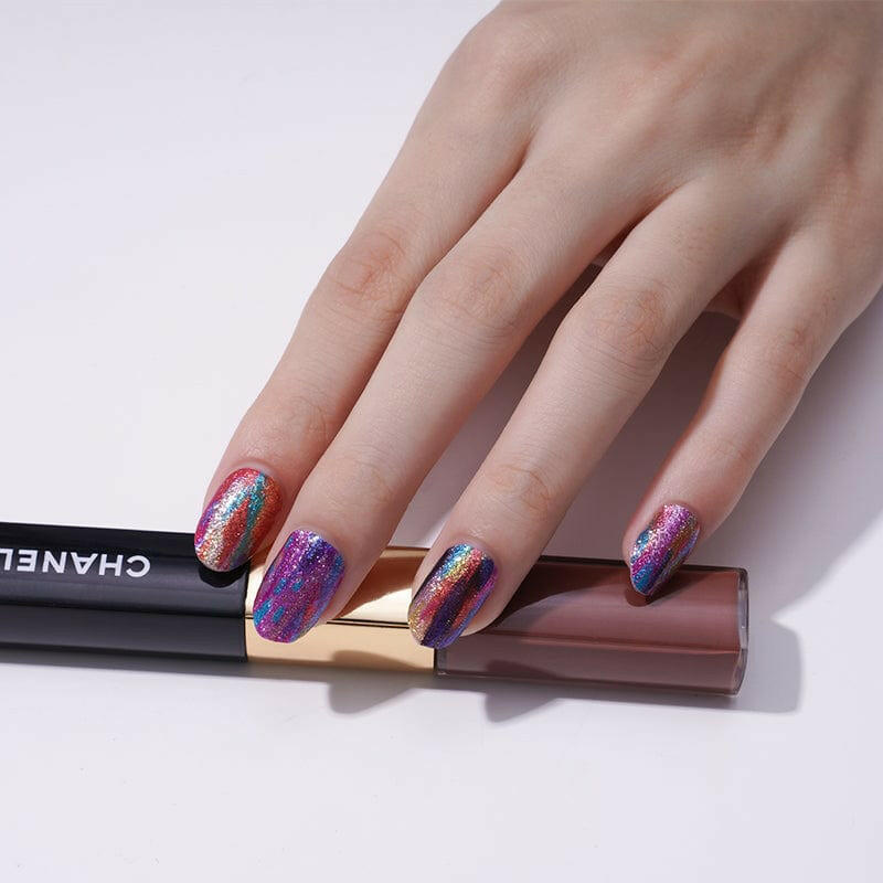 Hand wearing vibrant rainbow nail wraps with artistic brushstroke pattern