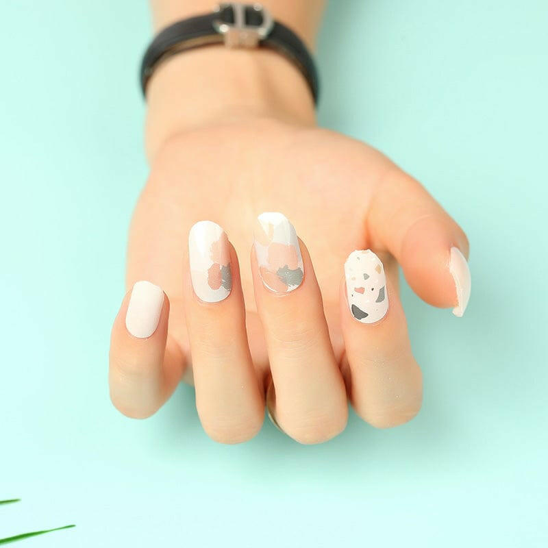 Terrazzo nail wraps on hand featuring minimalist nude base with grey speckles
