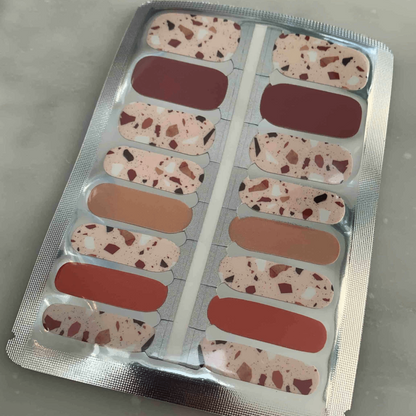 Terrazzo nail wraps with speckled brown and rust pattern in packaging for at-home manicures