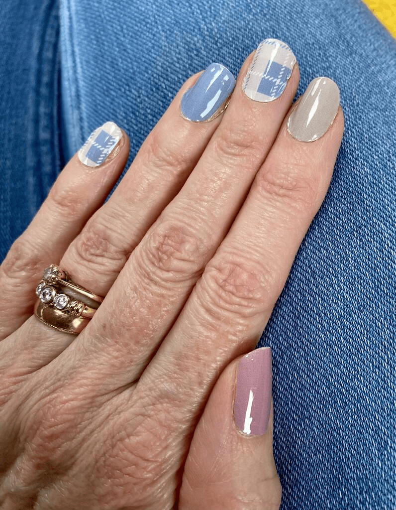 Tartan nail wraps in blue pink grey plaid pattern on hand with ring