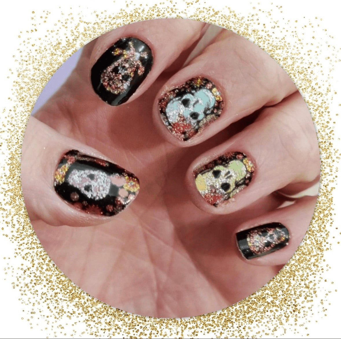 Black nail wraps with colourful glittery sugar skull designs on hand for Halloween manicure