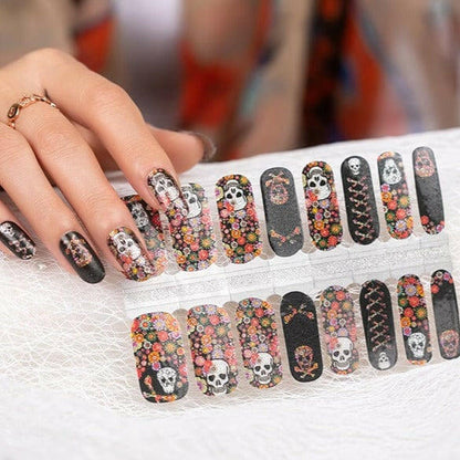 Hand holding Day of the Dead nail wraps sheet with skull and floral designs