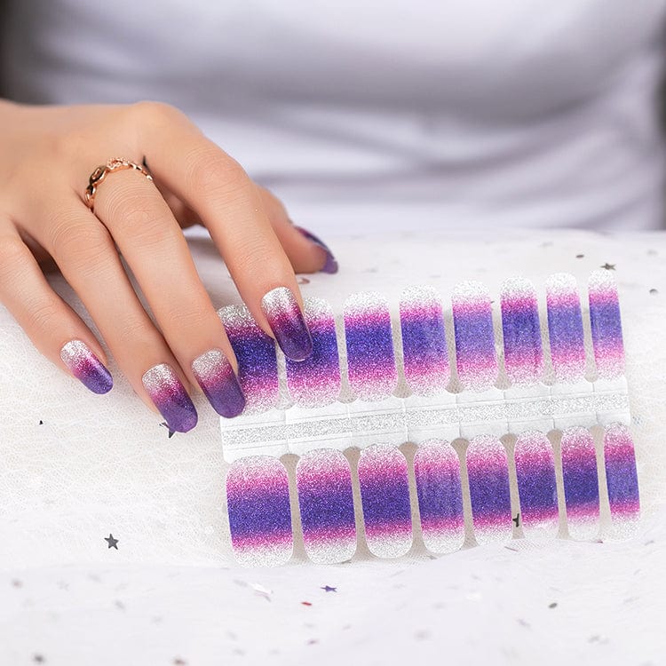 Purple ombre glitter nail wraps on hand with matching strip samples for at-home manicure