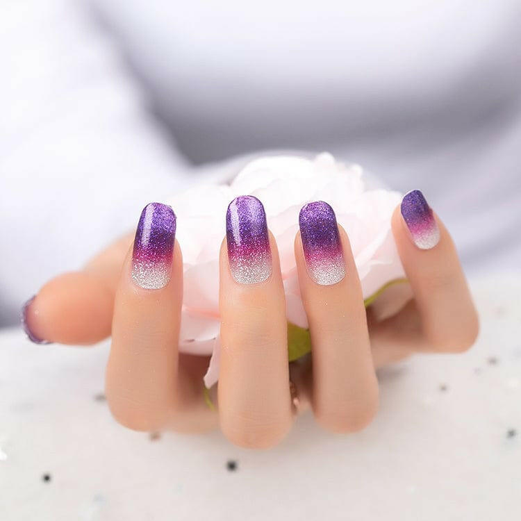 Purple ombre glitter nail wraps on hand showing violet to clear gradient effect