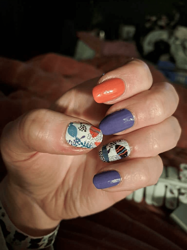 Hand displaying blue orange and marine pattern nail wraps with glossy finish manicure