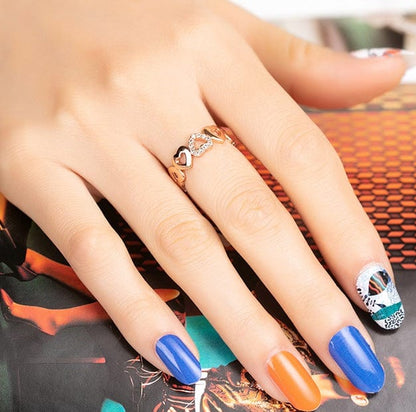Hand showing ocean themed nail art with blue coral patterns and orange accent nails