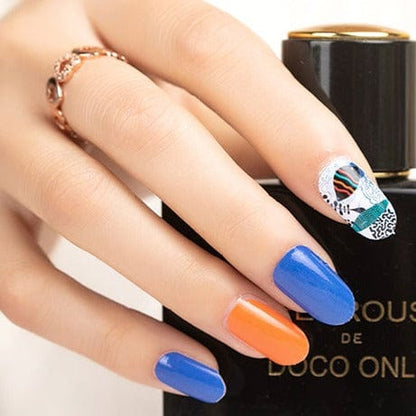 Blue and orange gel nail wraps with seahorse and marine patterns on hand holding nail polish bottle
