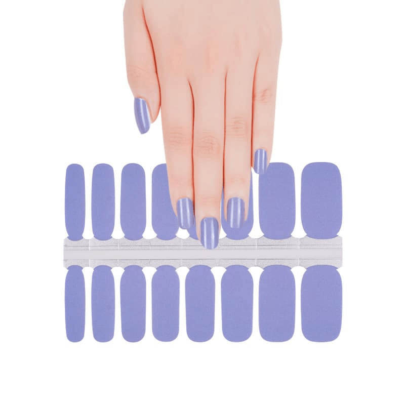 Hand selecting lavender purple nail wraps from sheet showing at-home manicure application process
