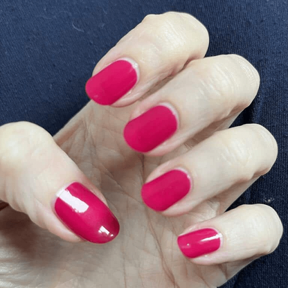 Hand wearing bright fuchsia pink non-UV nail wraps showing glossy finish manicure