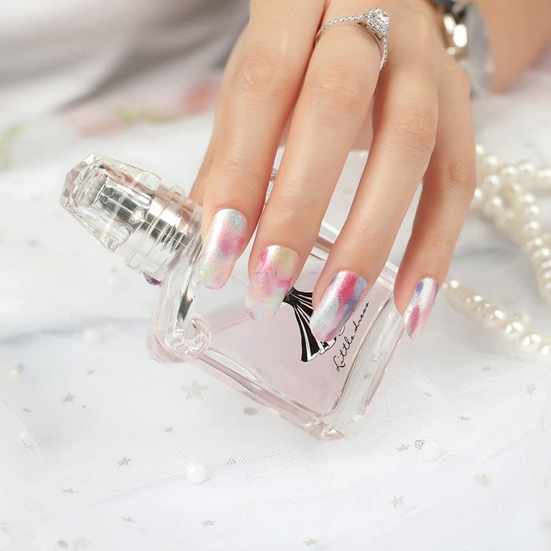 Hand wearing watercolour nail wraps with perfume bottle showing dreamy pastel nail art