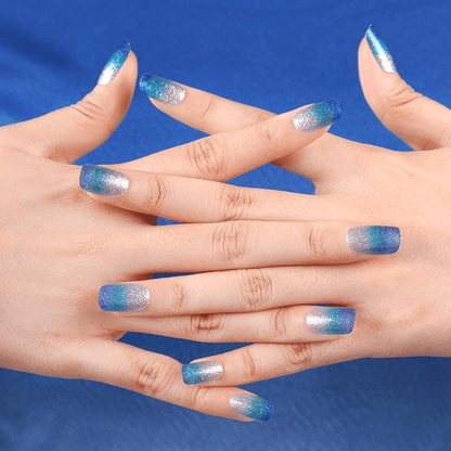 Blue ombre shimmer nail wraps on hands with glitter gradient design