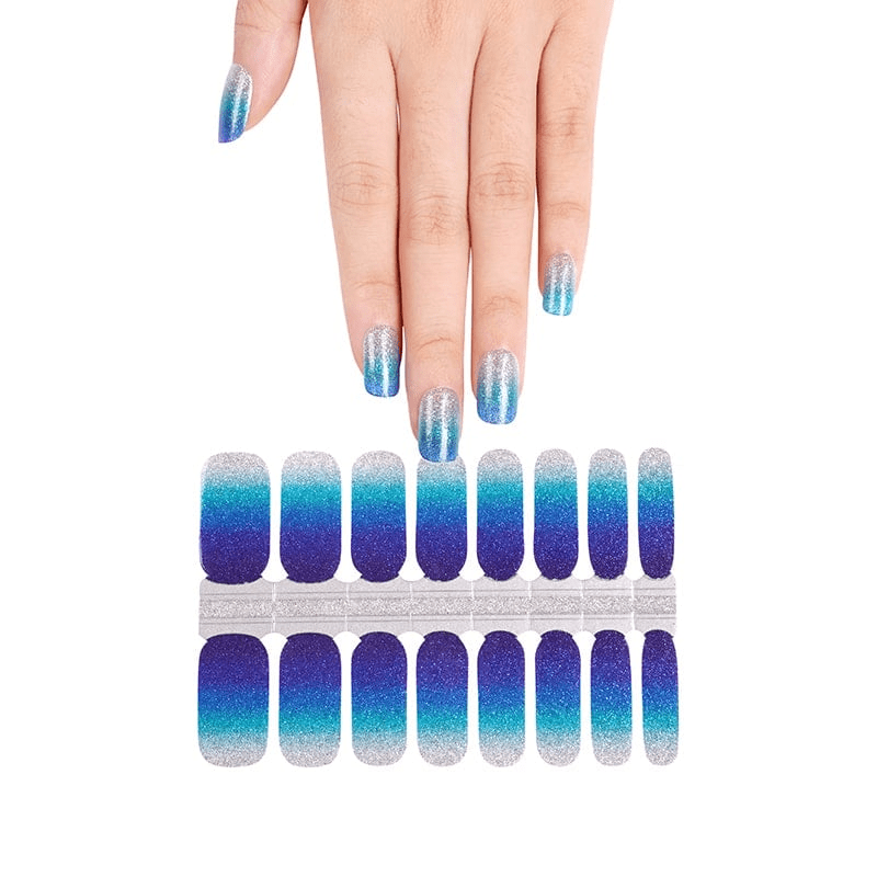 Hand displaying blue ombre nail wraps with matching nail wrap sheet below