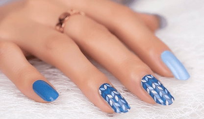 Blue wavy pattern non-UV nail wraps on hand showing geometric wave design