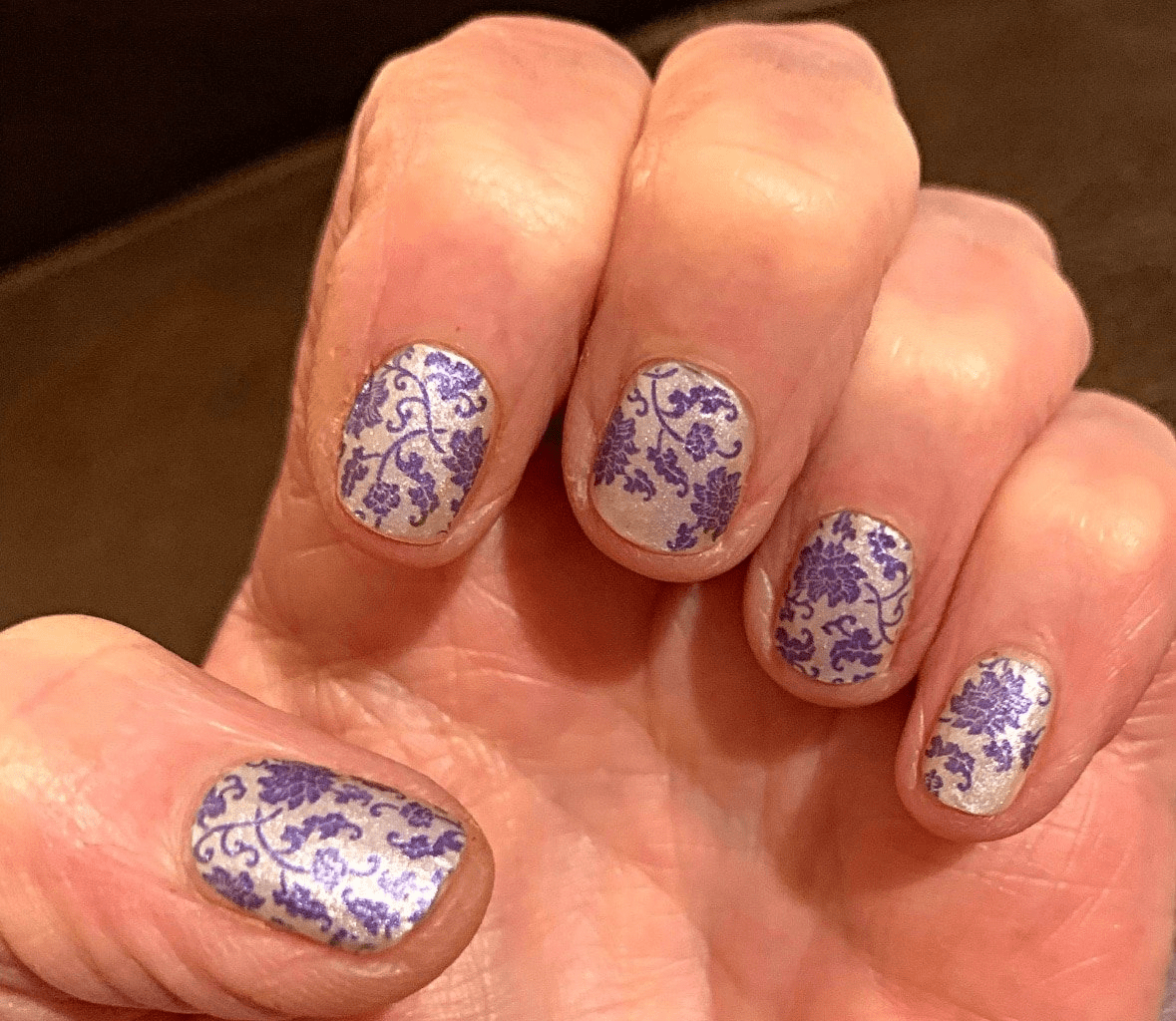 Blue floral porcelain pattern nail wraps on hand showing delicate china design at-home manicure