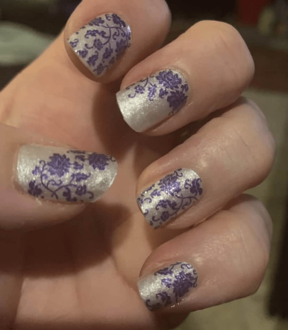 White and blue vintage china nail wraps on hand featuring elegant floral porcelain patterns