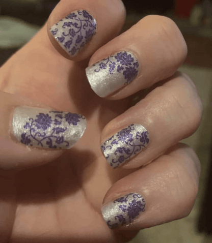 White and blue vintage china nail wraps on hand featuring elegant floral porcelain patterns