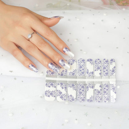 Hand with blue floral nail wraps beside nail wrap sheets showing porcelain design