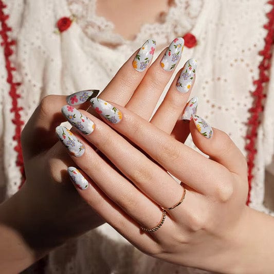 Floral nail wraps on hand showing multicoloured wildflower pattern with daisies for at-home manicure