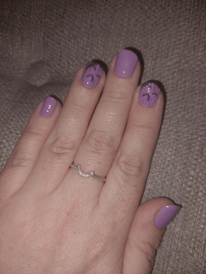 Gothic purple gradient nail wraps with flying bats design on hand for Halloween manicure