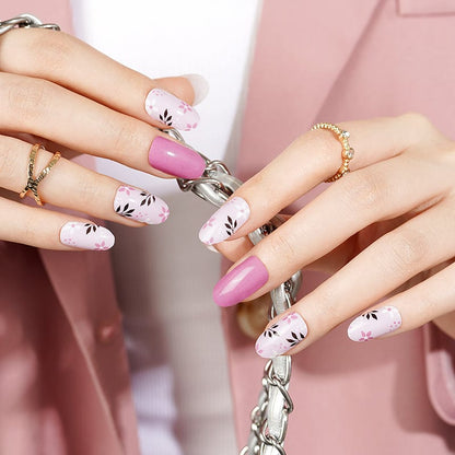 Hands wearing pink and white floral nail wraps with botanical leaf designs