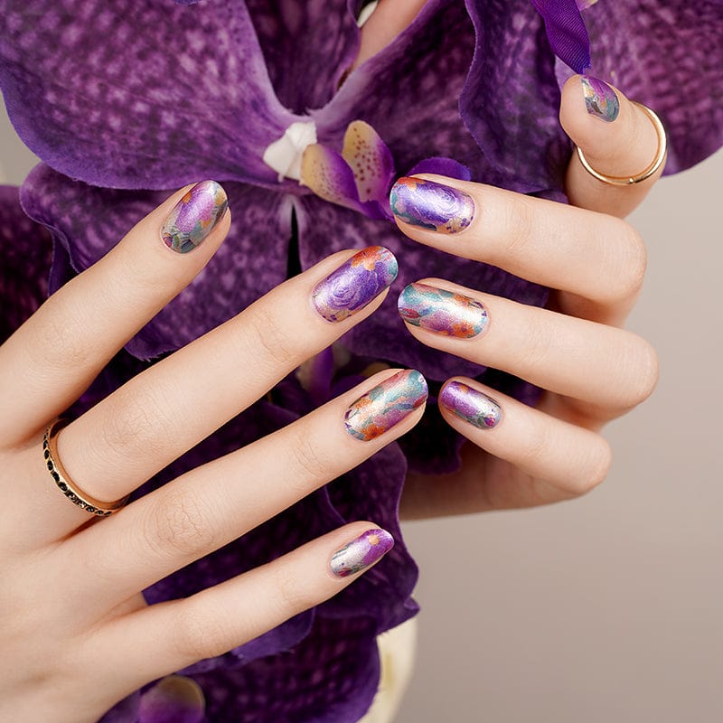 Chrome mirror nail wraps on hand with purple orchid showing holographic finish