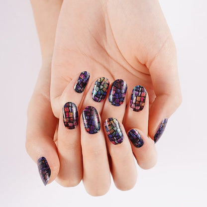 Hand displaying iridescent mosaic nail wraps with multicoloured holographic pattern