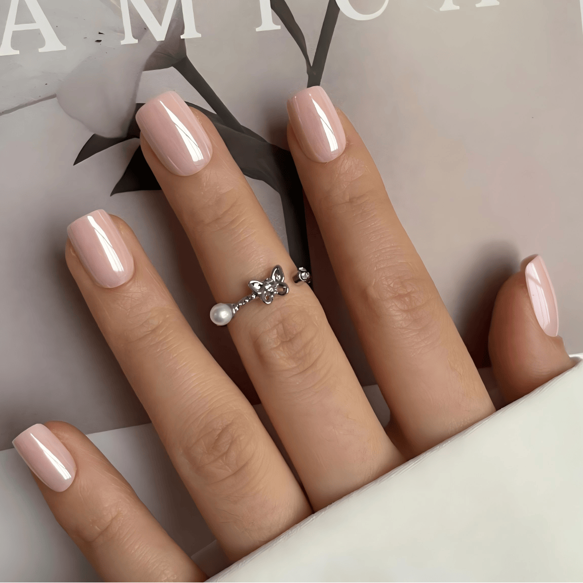 Nude glazed press-on nails in short square shape worn on hand with ring