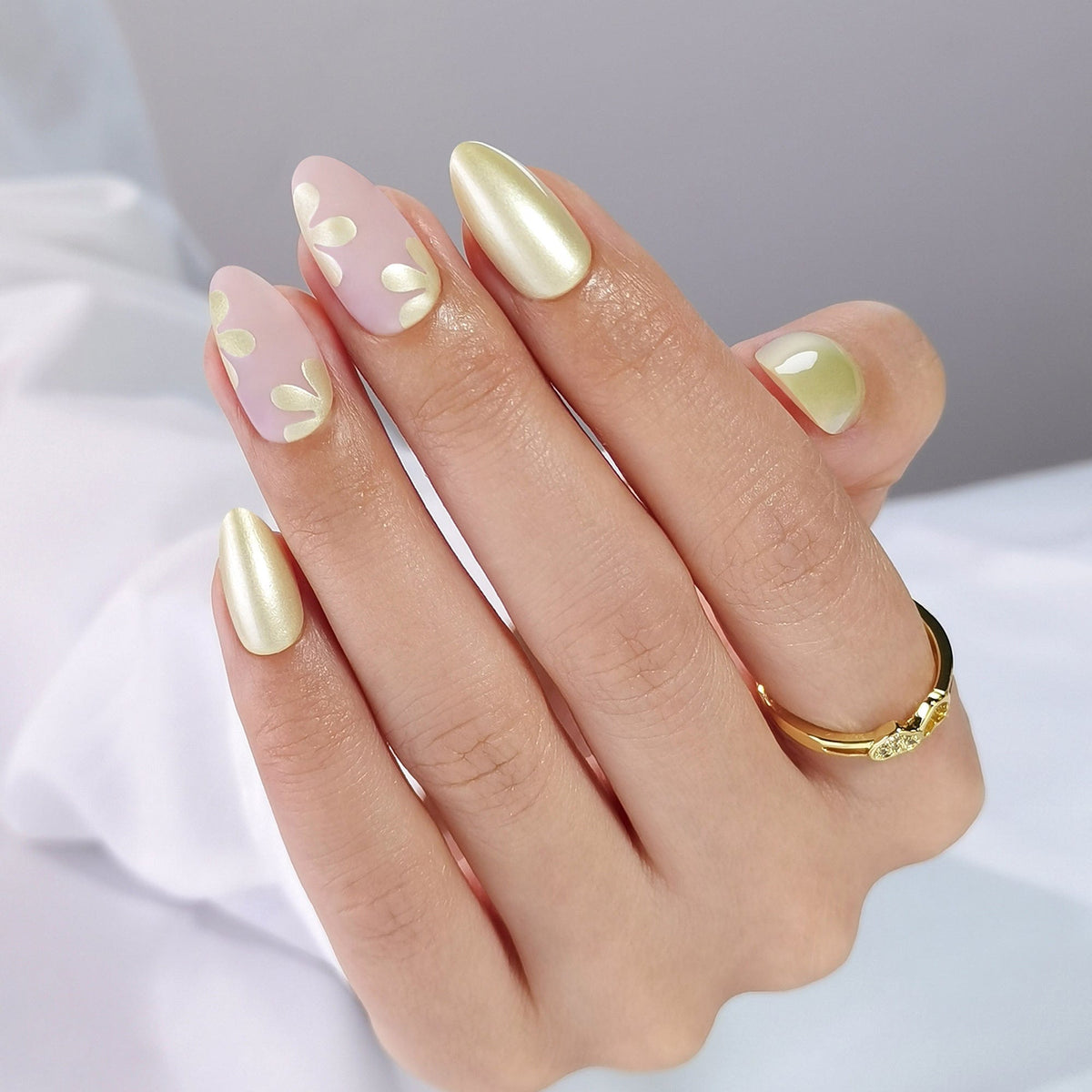 Pearl flower press-on nails on hand featuring white floral designs with chrome accents