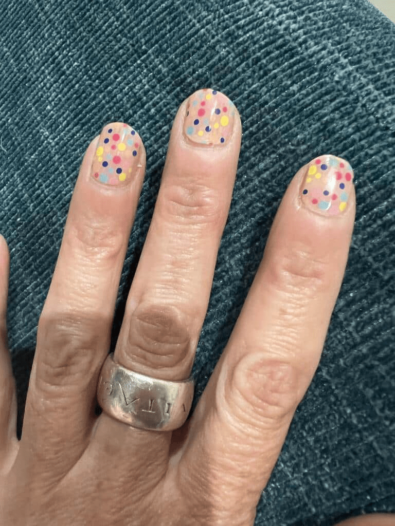 Confetti nail art gel wraps with multicoloured dots applied on natural nails