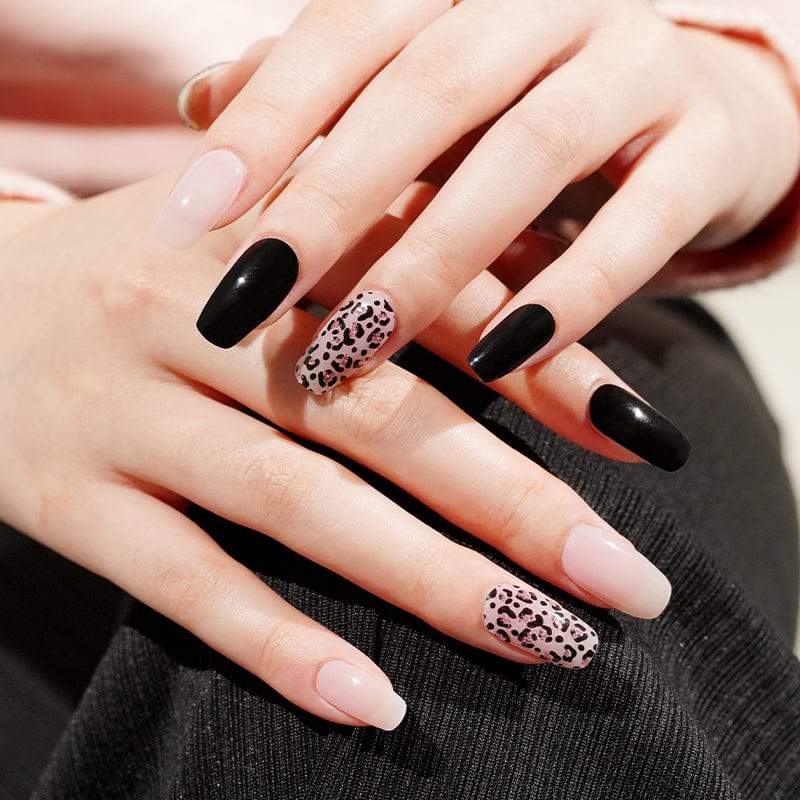 Black glossy and leopard print gel nail wraps on hands at-home manicure