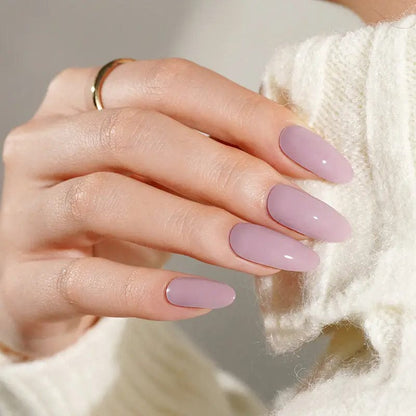 Mauve gel nail wraps on hand in cream jumper showing glossy lilac manicure