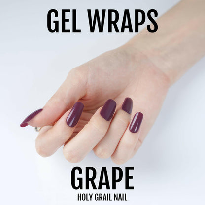 Deep burgundy gel nail wraps on hand showing glossy wine-coloured at-home manicure finish