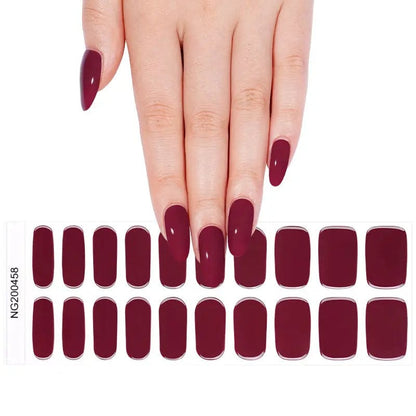 Hand displaying deep burgundy gel nail wraps with matching nail strip sheet