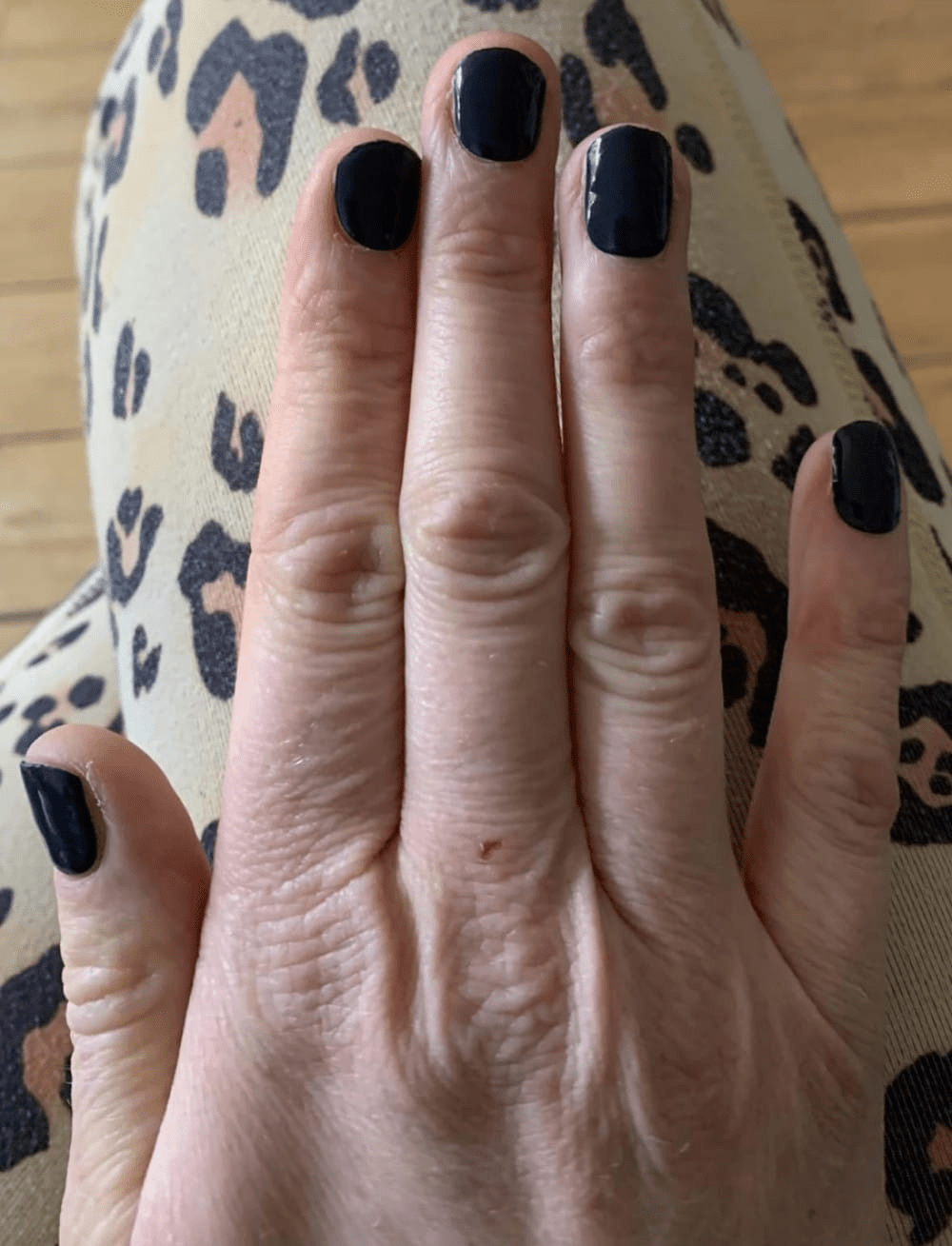 Black glossy gel nail wraps on hand showing midnight solid colour manicure