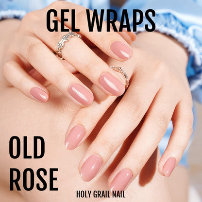 Two hands wearing glossy dusty pink gel nail wraps showing professional salon quality finish