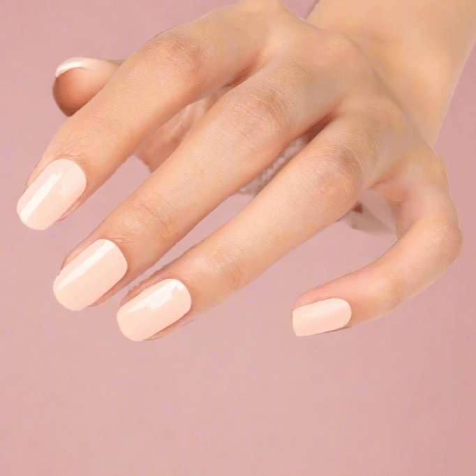 Peach gel nail wraps on hand displaying glossy coral nail art manicure