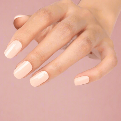 Peach gel nail wraps on hand displaying glossy coral nail art manicure