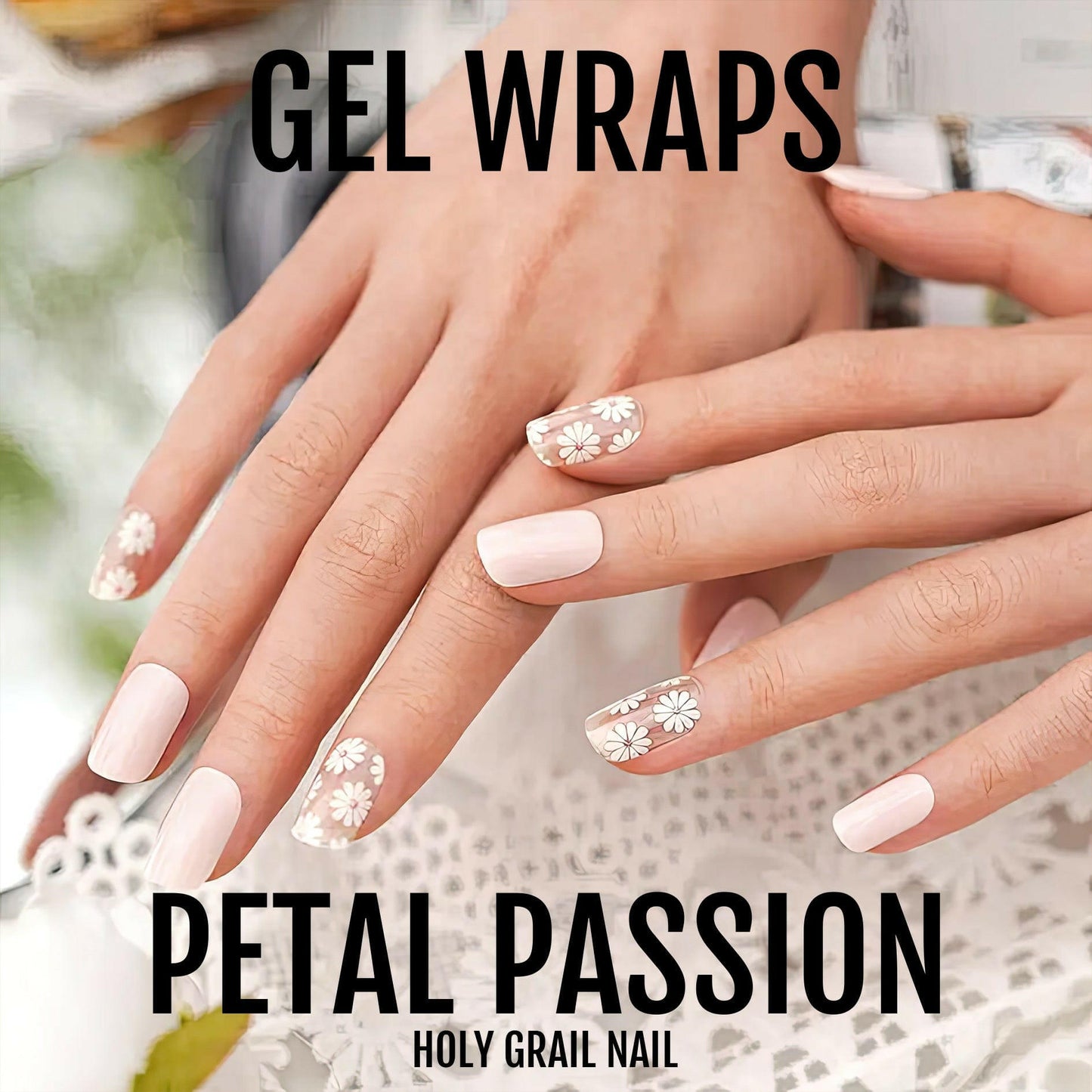 Hands wearing pink gel nail wraps with white flower patterns for at-home manicure