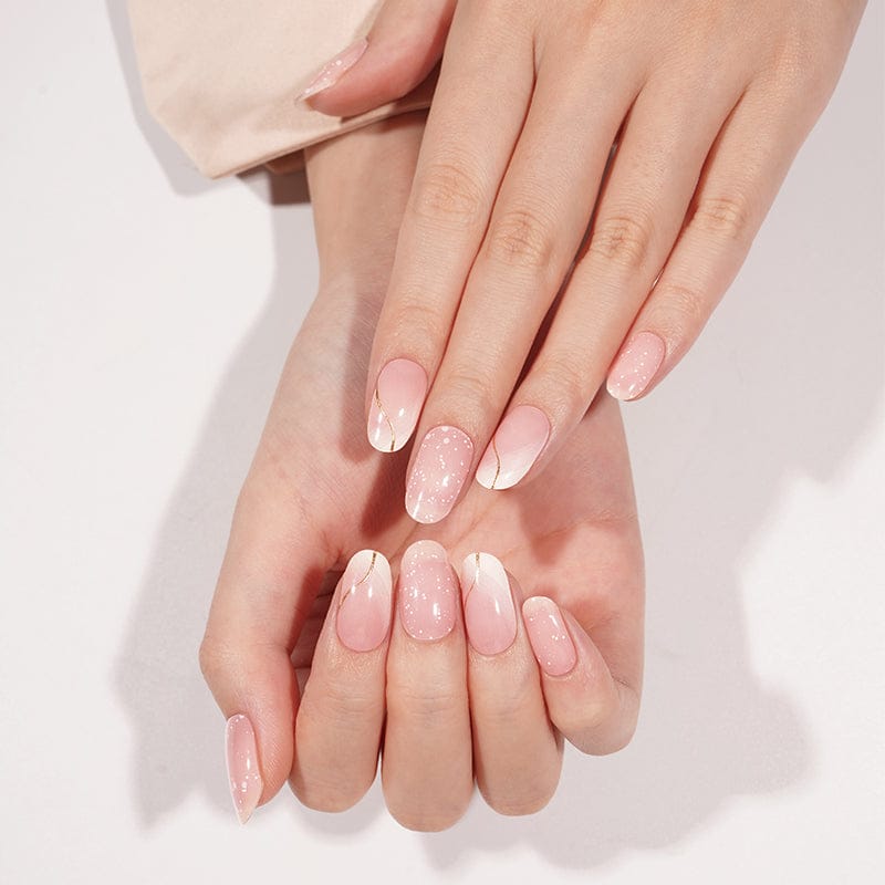 Soft pink gel nail wraps with pearl shimmer and white tips displayed on crossed hands
