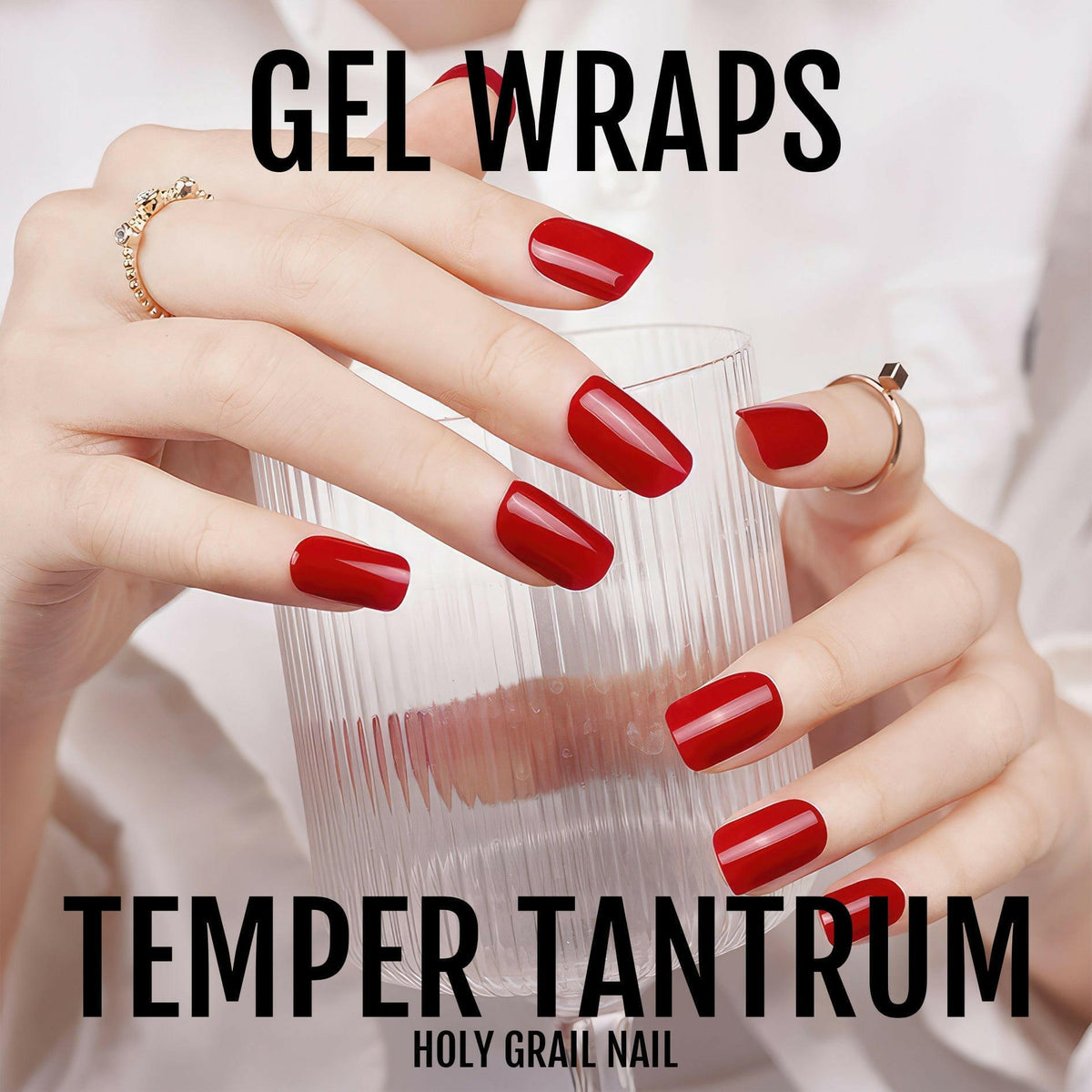 Hands holding glass showing red gel nail wraps with glossy crimson finish