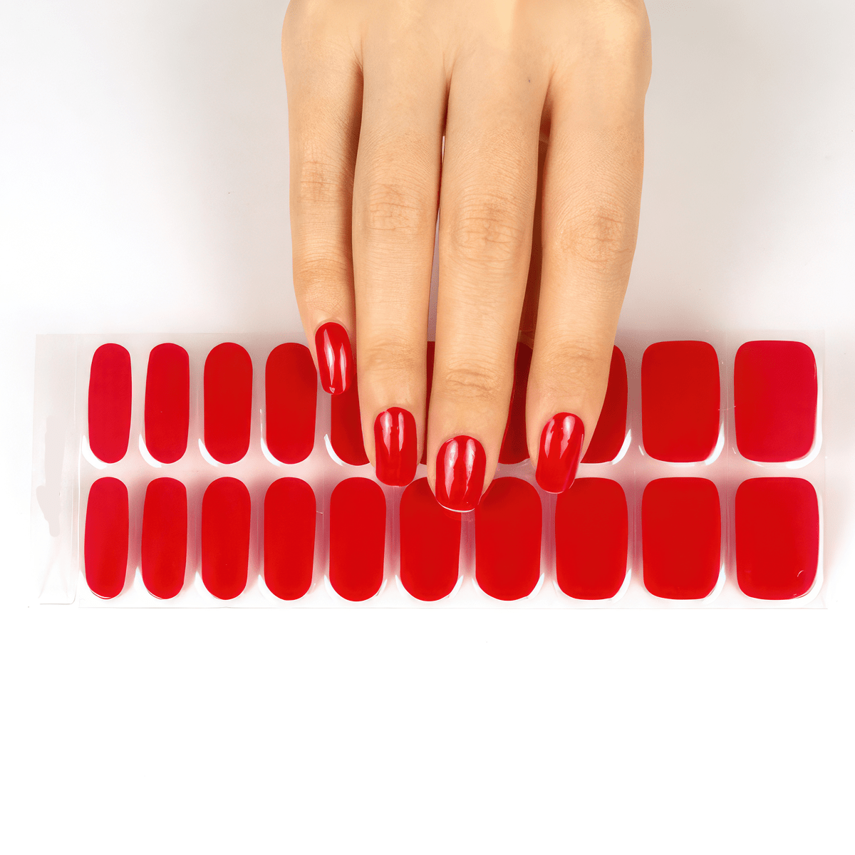 Red gel nail wraps applied on hand showing glossy finish manicure