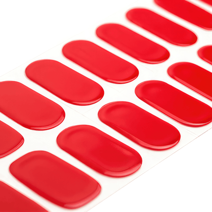 Red gel nail wraps sheet showing glossy crimson strips for at-home manicure