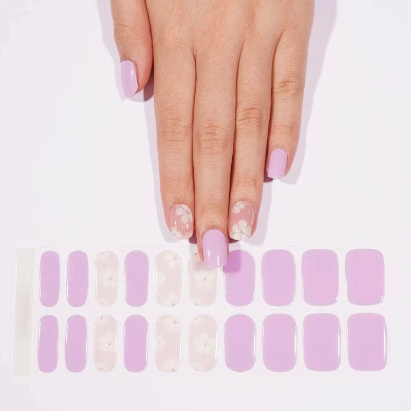 Pastel purple gel nail wraps with delicate white flower designs for feminine manicure