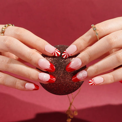 Holiday gel nail wraps with red French tips and white snowflake designs on hands