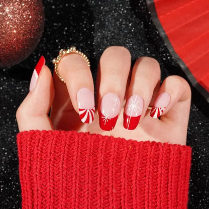 Red and pink Christmas French tip gel nail wraps with white snowflake patterns on hand
