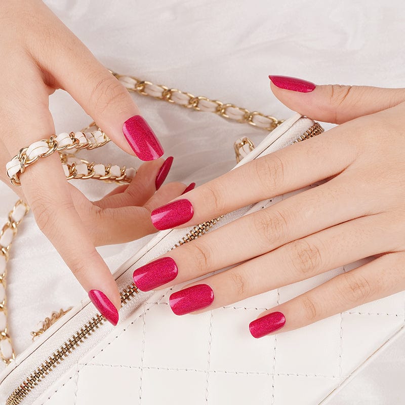 Pink glitter gel nail wraps on hands with gold jewellery nail art